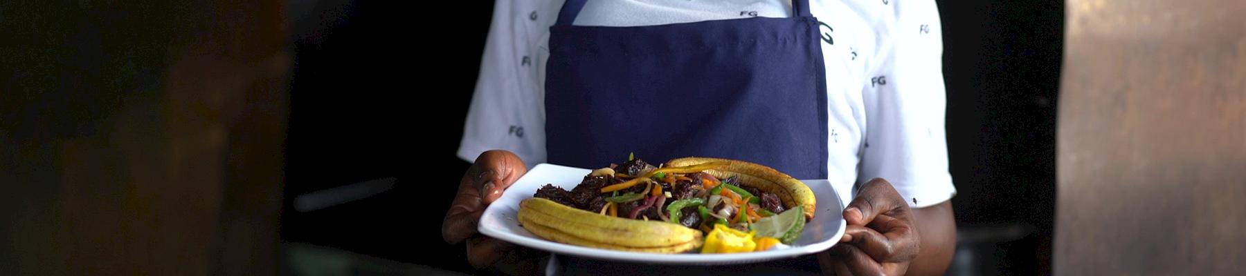 A restaurant owner in Tanzania presents a dish of wild-caught antelope. Integrating a One Health approach to Tanzania's wild meat industry is helping to strengthen existing sustainability, health, and conservation frameworks. Photo: S. Obae / TRAFFIC