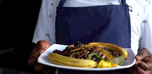 A restaurant owner in Tanzania presents a dish of wild-caught antelope. Integrating a One Health approach to Tanzania's wild meat industry is helping to strengthen existing sustainability, health, and conservation frameworks. Photo: S. Obae / TRAFFIC